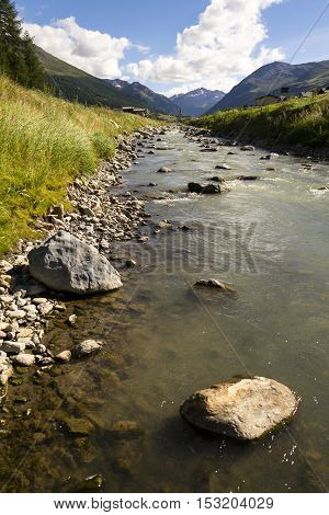 Spol River With Church Of Santa Maria In Livigno, Italy