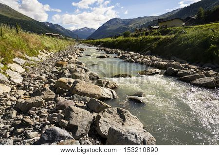 Spol River With Church Of Santa Maria In Livigno, Italy