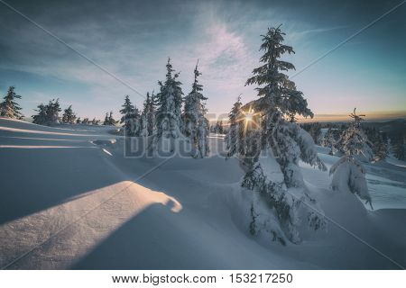 Fantastic orange evening landscape glowing by sunlight. Dramatic wintry scene with snowy trees. Kukul ridge, Carpathians, Ukraine, Europe. Toned like Instagram filter