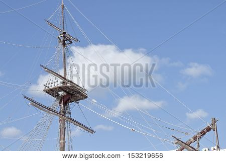 foreground of mast and crows nest of a ship with sky in the background