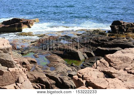 Waves crashing against rocks along the coast of Maine.