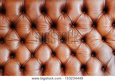 Genuine leather upholstery rich background. Leather furniture texture in brown tones. Luxury lifestyle concept
