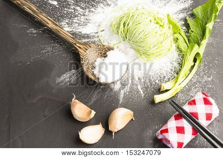 Green dried noodles same egg noodles and  on flour powder and ingredient on black background.Close up and top view.002