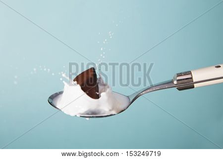 splash portrait of spoon with chocolate and milk