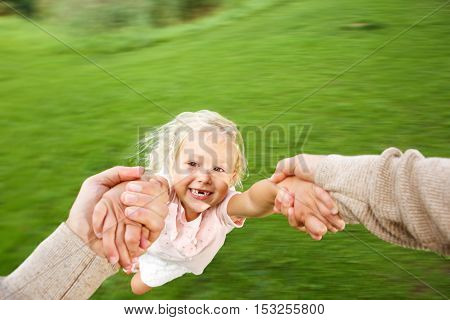 Cute Little Girl Being Spun In Circles At Park