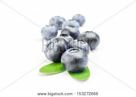 Fresh ripe blueberries with leaves on white background.