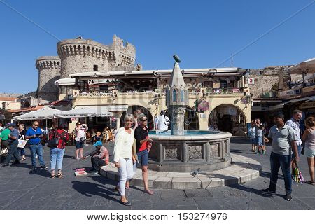 Rhodes, Greece - October 18, 2016: View of Rhodes old city center  square with restaurants and fountain, the old city of Rhodes is surrounded by aincent walls.