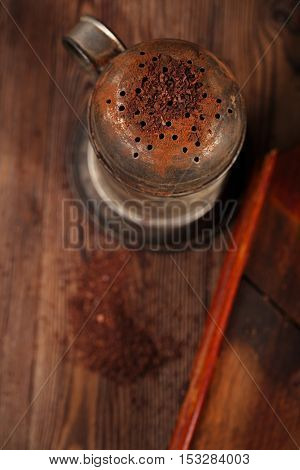 vintage sifter with grated chocolate and  100% chocolate block