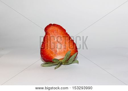 cut red strawberries with green tail on a white background