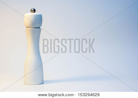Modern salt grinder made of wood, painted white, standing on a white background, top view