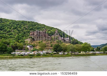 Trechtingshausen Germany - May 23 2016: Reichenstein castle and Camping Marienort in cloudy weather on the Rhine Gorge near Trechtingshausen Rhine Valley Rhineland-Palatinate Germany UNESCO World Heritage Site.