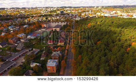 Street in auntumn in town near park by drone