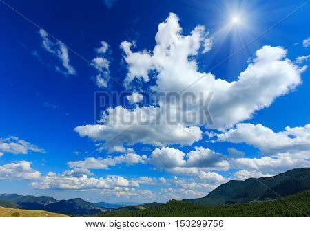 Blue Sunshiny Sky With White Clouds Over Mountain.