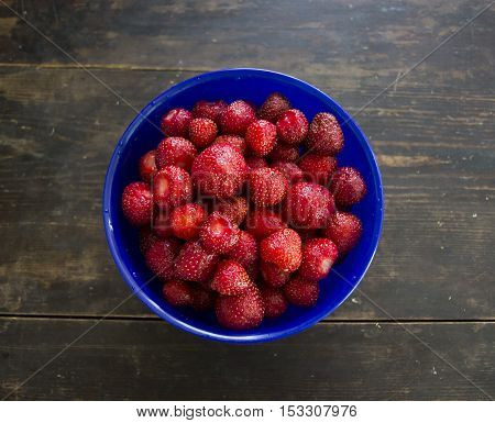 bowl of strawberries on a wooden table
