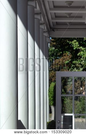 Door with glass on the background of the park and the colonnade of the facade in perspective. Riga
