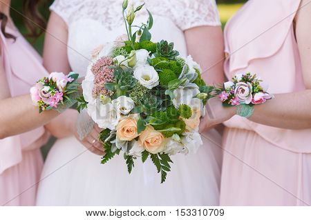 bride with bridesmaids are holding wedding bouquets.