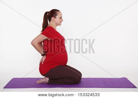 young pregnant woman is practicing yoga, studio