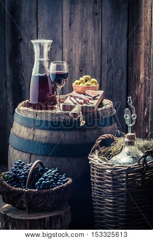 Homemade Red Wine With Olives, Cold Meats, Grapes And Demijohn