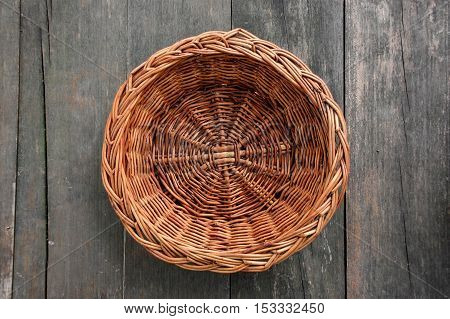 wood weave hand made fruit basket on wood texture table outdoor, in a garden, top view