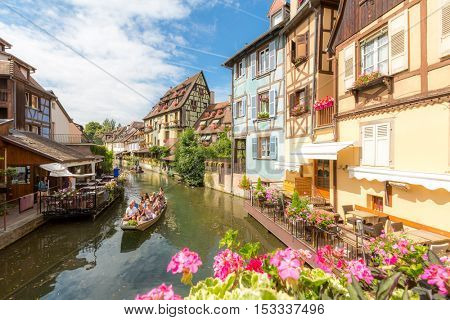 COLMAR - JUL 13: Unidentified tourists riding boat in La Lauch at La Petite Venise on JUL 13, 2015. Colmar is situated on the Alsatian Wine Route and considers itself to be capital of Alsatian wine.