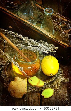 Still life with gingerlemonhoney and Provencal herbs on a wooden table