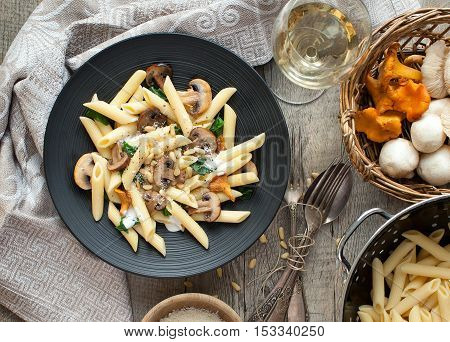 Pasta with seasonal mushrooms on rustic tabletop. Horizontal, view from above.