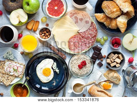 Big breakfast for the big family on the white rustic table.