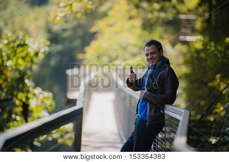 Young man with custom box mode vape device vaping an electronic cigarette outdoor at beautiful place outdoors.