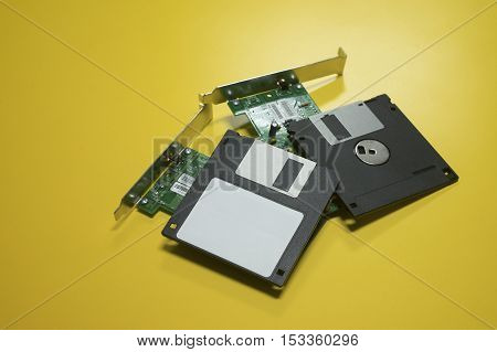 Floppy disk magnetic computer and electronic circuit board put on a yellow desk background.selective focus