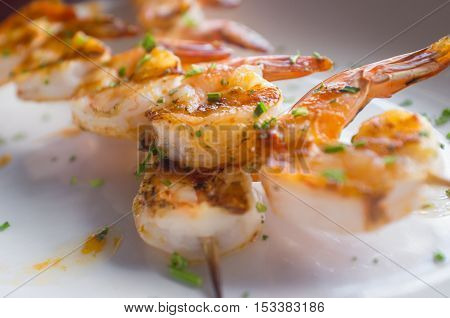Fresh hot grilled jumbo shrimp kebabs with parsley