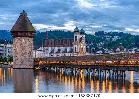 Night view towards Chapel Bridge (Kapellbruecke) together with the octagonal tall tower (Wasserturm) it is one of the Lucerne's most famous tourists attraction