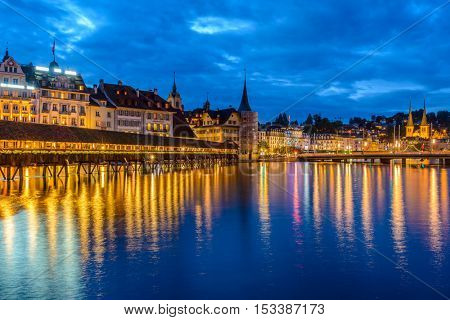 Night view towards Chapel Bridge (Kapellbruecke) together with the octagonal tall tower (Wasserturm) it is one of the Lucerne's most famous tourists attraction