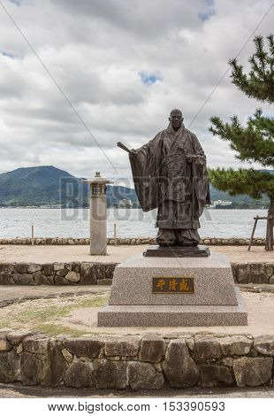 Hiroshima Japan - September 20 2016: Statue of Taira No Kiyomori 12th century military leader at the shore of Miyajima Island. He was the benefactor of the Itsukushima Shinto Shrine. Inland Sea in back.