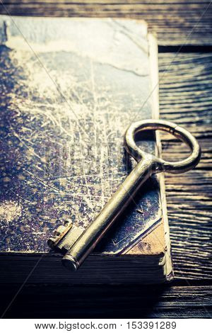 Closeup of aged books and keys on old wooden table