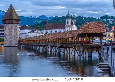 Night view towards Chapel Bridge (Kapellbruecke) together with the octagonal tall tower (Wasserturm) it is one of the Lucerne's most famous tourists attraction