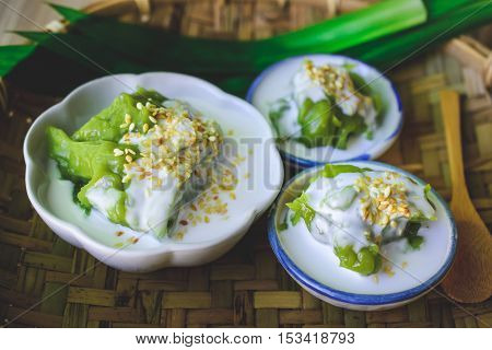 Delicious Thai Dessert Coconut sweet pudding with coconut milk topping on Threshing Basket