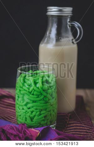 Lod Chong, Thai Dessert on Thai Textile with Wood Background Rice Noodles Made of Rice Eaten with Coconut Cream
