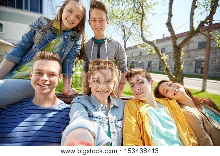 education, high school and people concept - group of happy teenage students or friends taking selfie