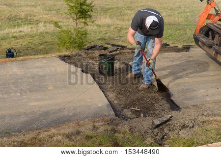 Colbert, WA - October 24, 2016: Workers of Black Diamond Asphalt Paving, LLC., repairing patches in a private road/driveway