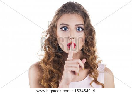 Woman requires silence. Young beautiful blonde woman has put forefinger to lips as sign of silence, isolated on white