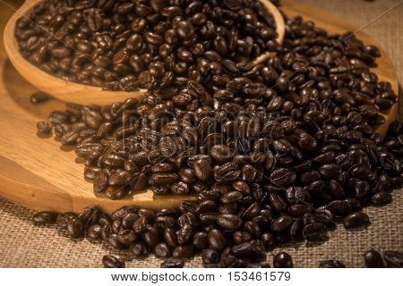 Coffee beans in wood plate place on hemp sack
