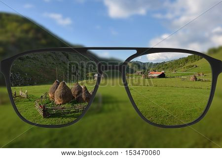 Clear image in glasses against blurry landscape
