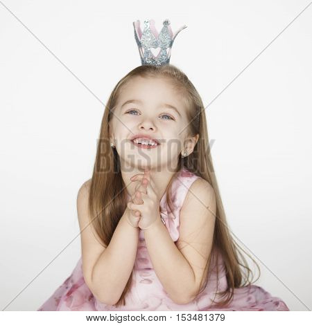 one cute girl child begging looking up and hoping for something. Princess kid holding hands together