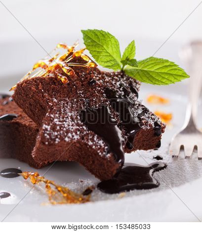 Homemade tasty delicious christmas dessert on a plate - brownie with caramel and chocolate sauce selective focus