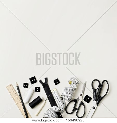 Everything for sewing in black and white. Fabric and thread zipper and buttons scissors and centimeter pencil and ruler.