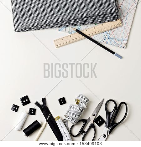 Everything for sewing in black and white. Fabric and thread zipper and buttons scissors and centimeter pencil and ruler.