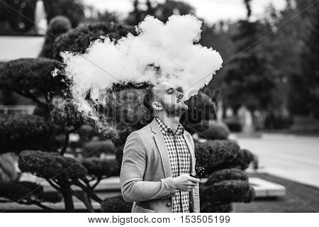 Men With Beard Smoking Electronic Cigarette Outdoor