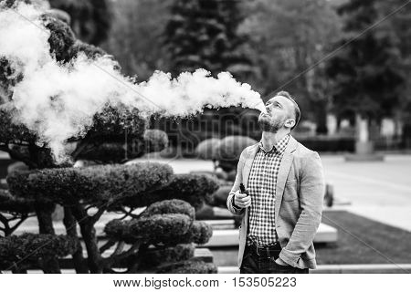 Men With Beard Smoking Electronic Cigarette Outdoor