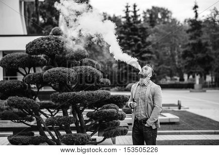 Men With Beard Smoking Electronic Cigarette Outdoor