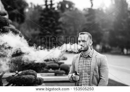 Men With Beard Smoking Electronic Cigarette Outdoor